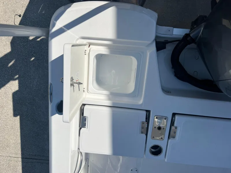 Slide: The Image of 2025 NauticStar 224 Bay boat deck with storage compartments and motor. - 31