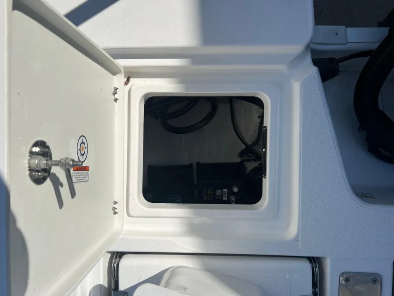 Slide: The Image of 2025 NauticStar 224 Bay boat storage compartment with open hatch. - 32