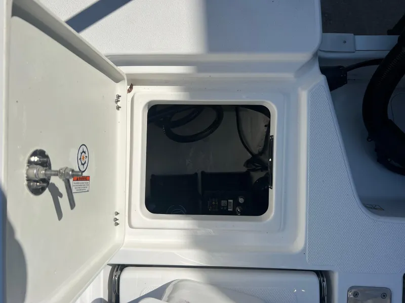 Slide: The Image of 2025 NauticStar 224 Bay boat storage compartment with open hatch. - 33