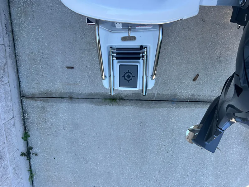 Slide: The Image of 2025 NauticStar 224 Bay boat ladder and motor on concrete surface. - 34