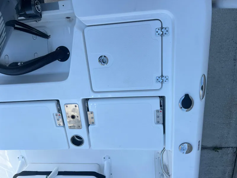 Slide: The Image of 2025 NauticStar 224 Bay boat deck with storage compartments and fixtures. - 35