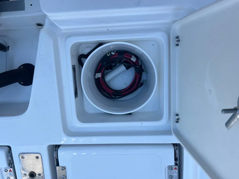 Slide: The Image of 2025 NauticStar 224 Bay boat storage compartment with coiled cables. - 36
