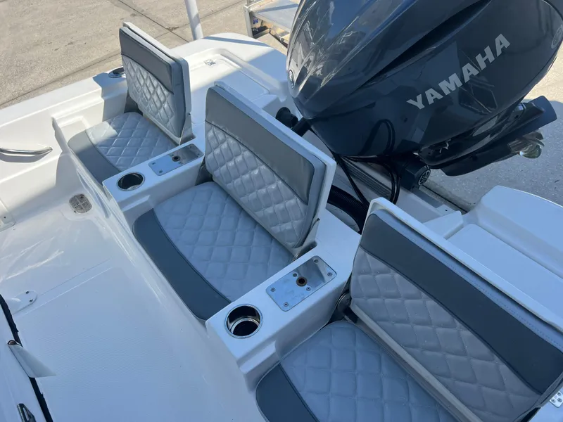 Slide: The Image of 2025 NauticStar 224 Bay boat seats with Yamaha engine, featuring quilted upholstery and cup holders. - 37