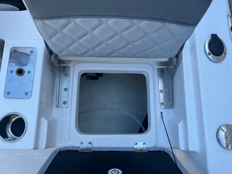 Slide: The Image of Open storage compartment on 2025 NauticStar 224 Bay boat with cushioned seat. - 38