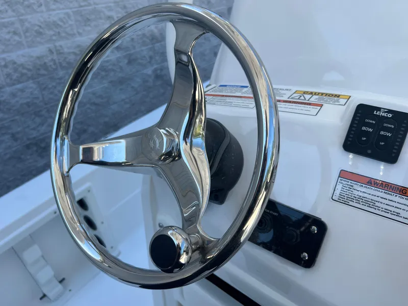 Slide: The Image of 2025 NauticStar 224 Bay steering wheel and dashboard controls. - 48