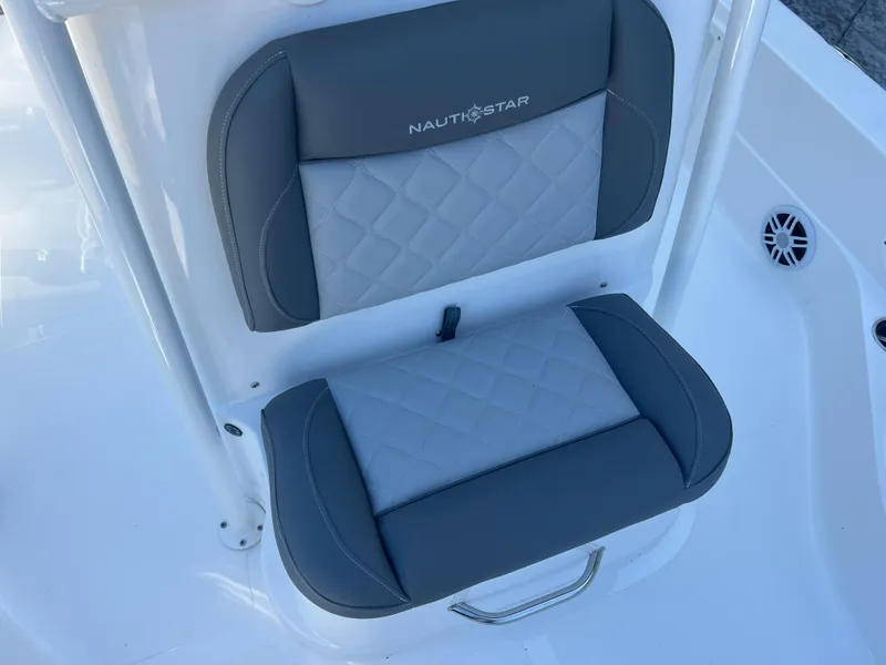 Slide: The Image of 2025 NauticStar 224 Bay boat seat with gray and white cushioned design. - 7