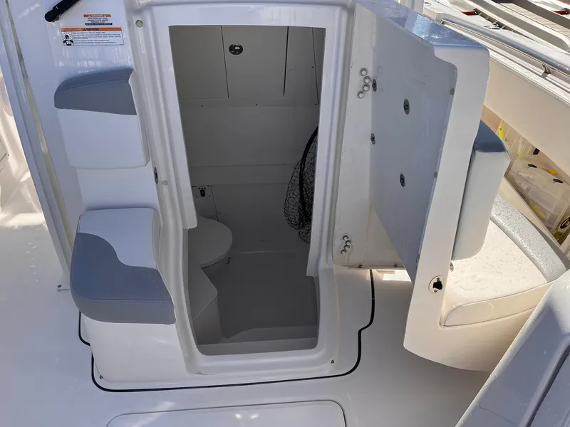 Slide: The Image of 2023 Robalo R302 Center Console boat interior with open storage compartment and seating. - 5