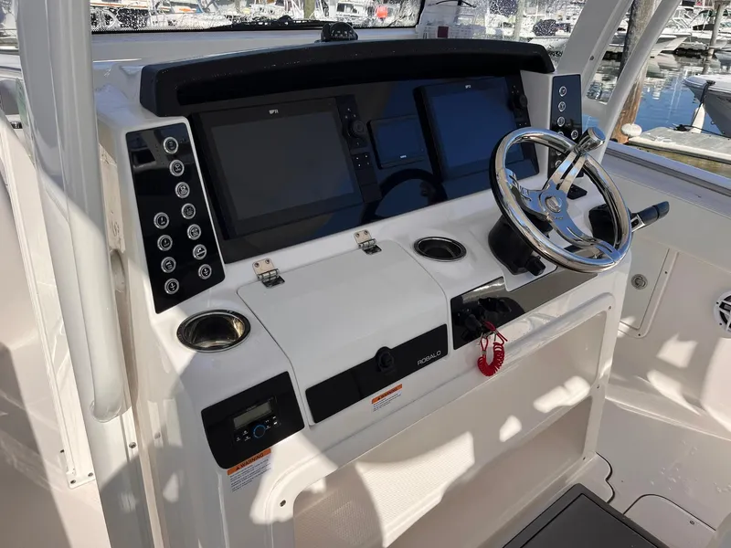 Slide: The Image of 2023 Robalo R302 Center Console boat dashboard with steering wheel and electronic displays. - 6