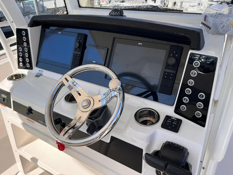 Slide: The Image of 2023 Robalo R302 Center Console dashboard with dual screens and steering wheel. - 8