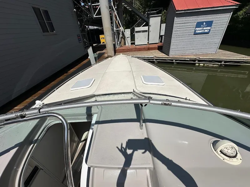 Slide: The Image of Front view of a 2000 Formula 330 SS boat docked near a wooden building. - 19