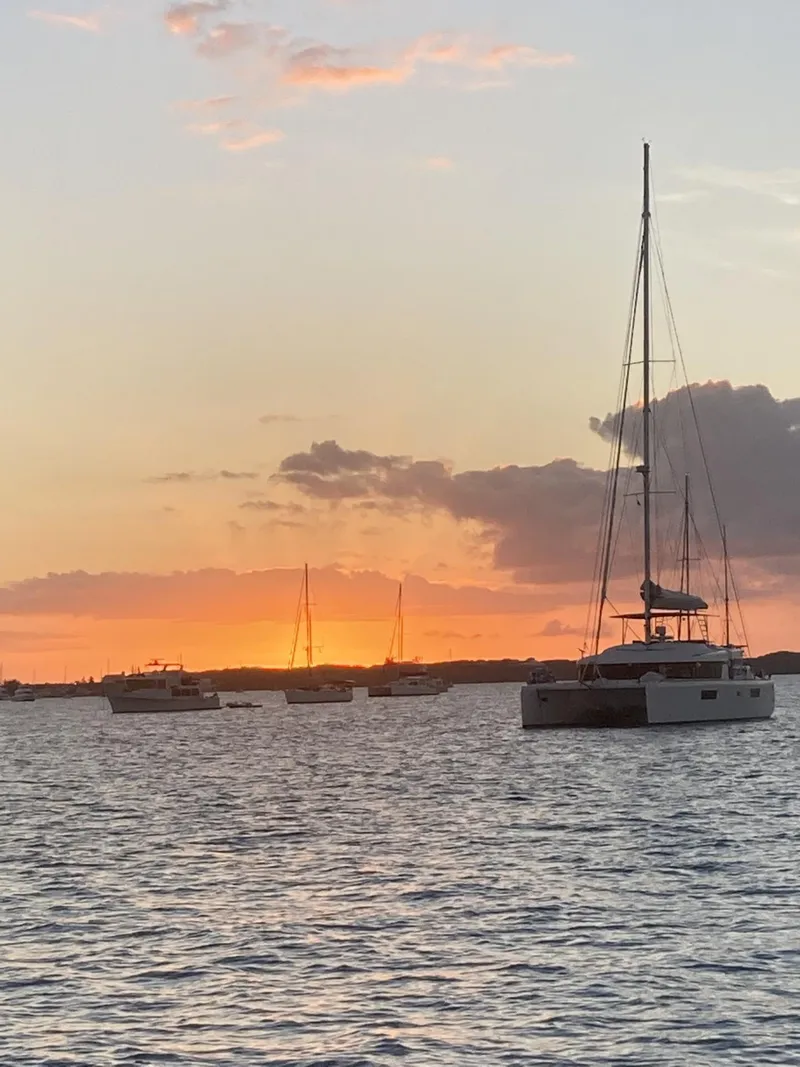 Slide: The Image of Sailboats on tranquil water at sunset, featuring a 2010 Broadblue 435 catamaran. - 12