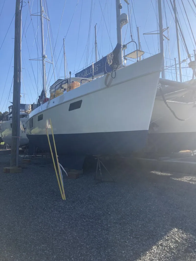 Slide: The Image of Broadblue 435 catamaran from 2010 on dry dock, surrounded by other boats. - 14