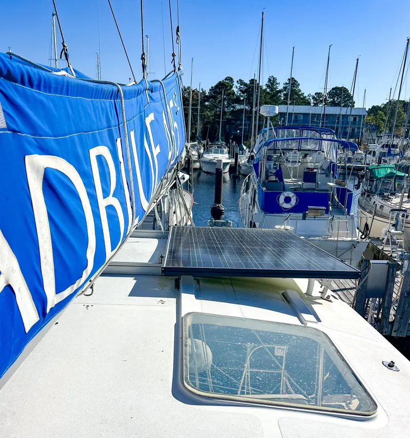 Slide: The Image of Broadblue 435 catamaran docked, featuring solar panel and blue sail cover, 2010 model. - 19