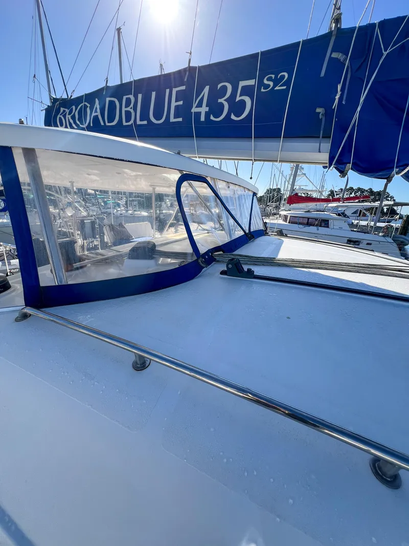 Slide: The Image of 2010 Broadblue 435 sailboat with blue sail cover, docked in marina under clear sky. - 21