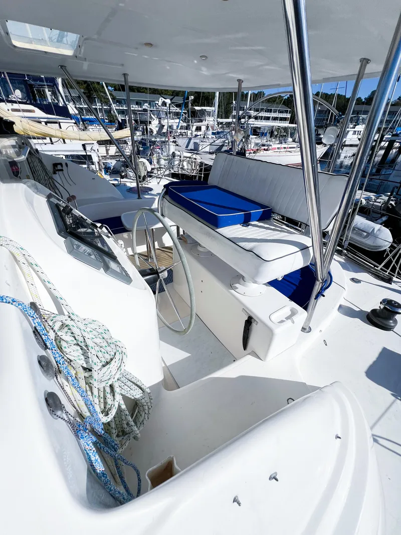 Slide: The Image of 2010 Broadblue 435 yacht cockpit with seating, steering wheel, and marina view. - 26