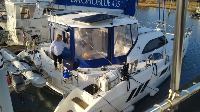 Slide: The Image of Broadblue 435 catamaran docked, 2010 model, with a person on deck. - 4