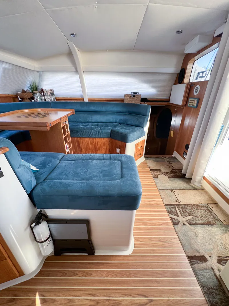 Slide: The Image of Interior of 2010 Broadblue 435 catamaran with blue seating and wooden flooring. - 43