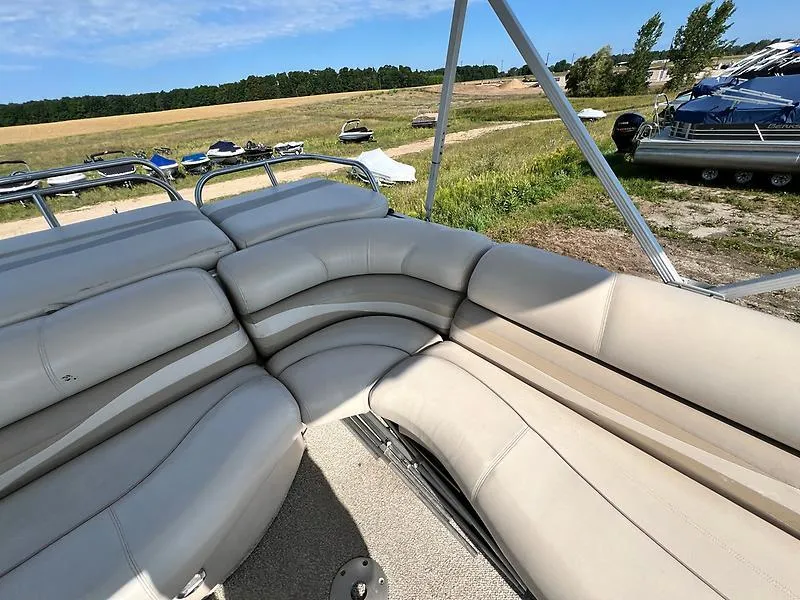 Slide: The Image of 2005 Crest 25 Savannah boat with beige seating, parked in a grassy area. - 13