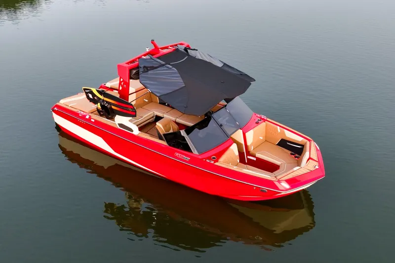 Slide: The Image of 2024 Nautique GS22 boat in vibrant red on calm water. - 10