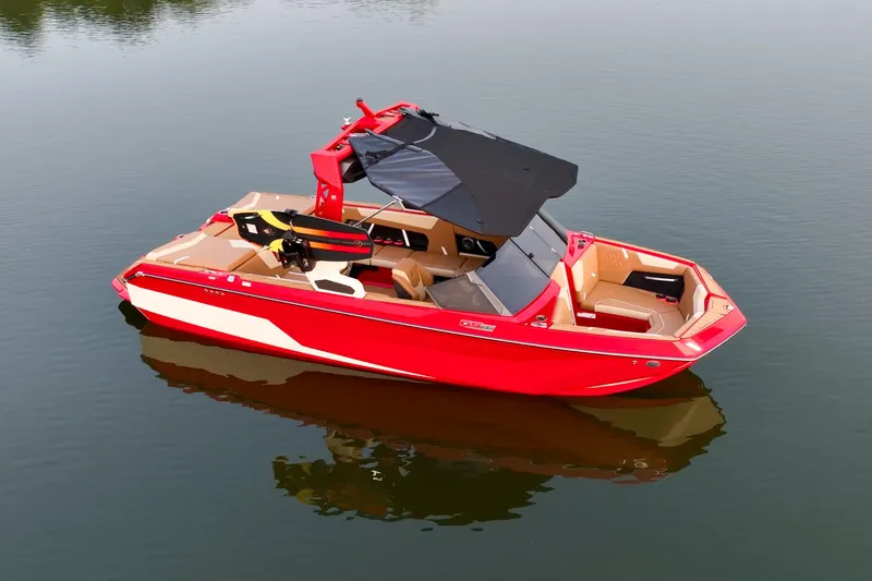 Slide: The Image of 2024 Nautique GS22 boat, red with black canopy, floating on calm water. - 5