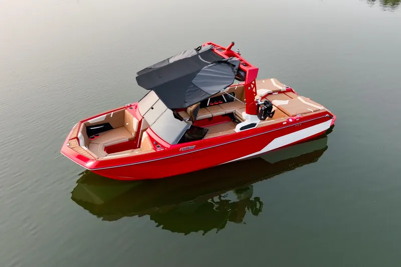 Slide: The Image of 2024 Nautique GS22 boat in red, floating on calm water, with a black canopy. - 7