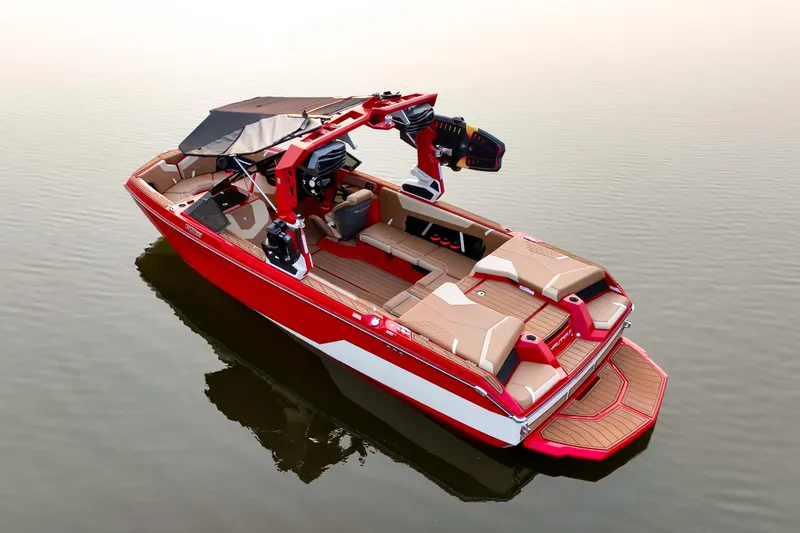 Slide: The Image of 2024 Nautique GS22 boat in red, floating on calm water, showcasing sleek design and spacious interior. - 8