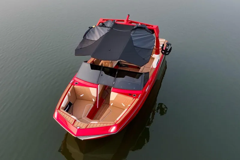 Slide: The Image of 2024 Nautique GS22 boat with black canopy on calm water. - 9