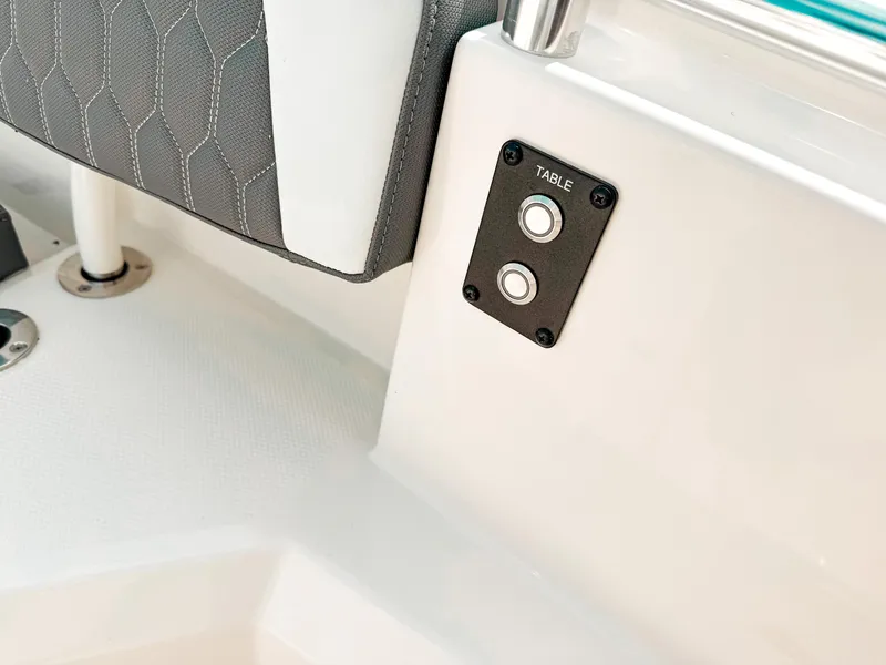Slide: The Image of 2025 Cobia 285 Center Console boat interior with table control buttons. - 18