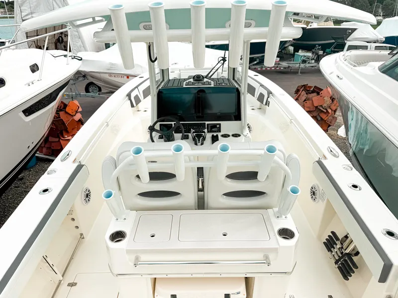 Slide: The Image of 2025 Cobia 285 Center Console boat interior with helm, seating, and rod holders. - 6