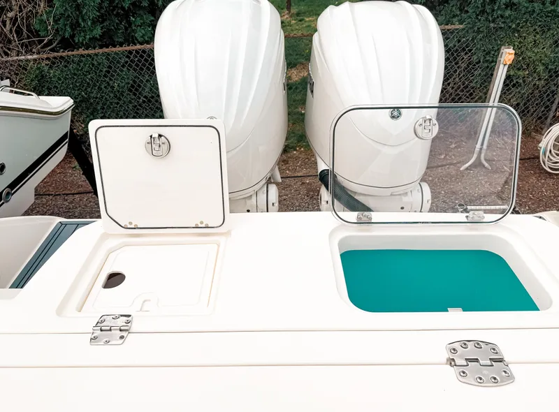 Slide: The Image of 2025 Cobia 285 Center Console with dual outboard engines and open storage compartments. - 8