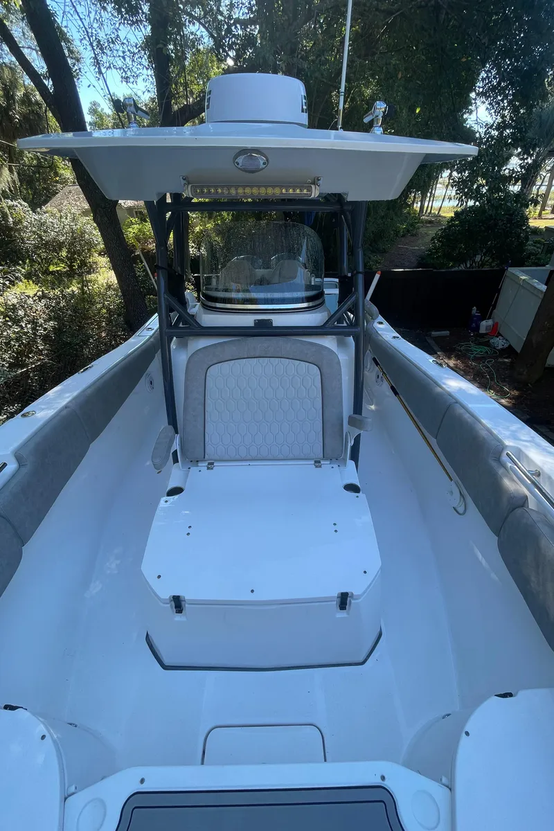 Slide: The Image of 2021 Sea Fox 288 Commander boat interior with seating and console, surrounded by trees. - 11