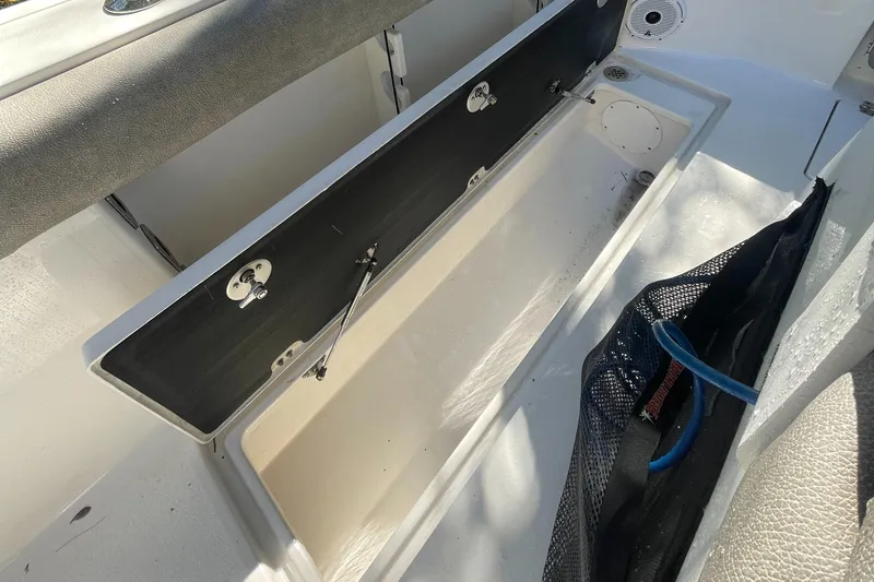 Slide: The Image of 2021 Sea Fox 288 Commander storage compartment with open lid and netted side pocket. - 16