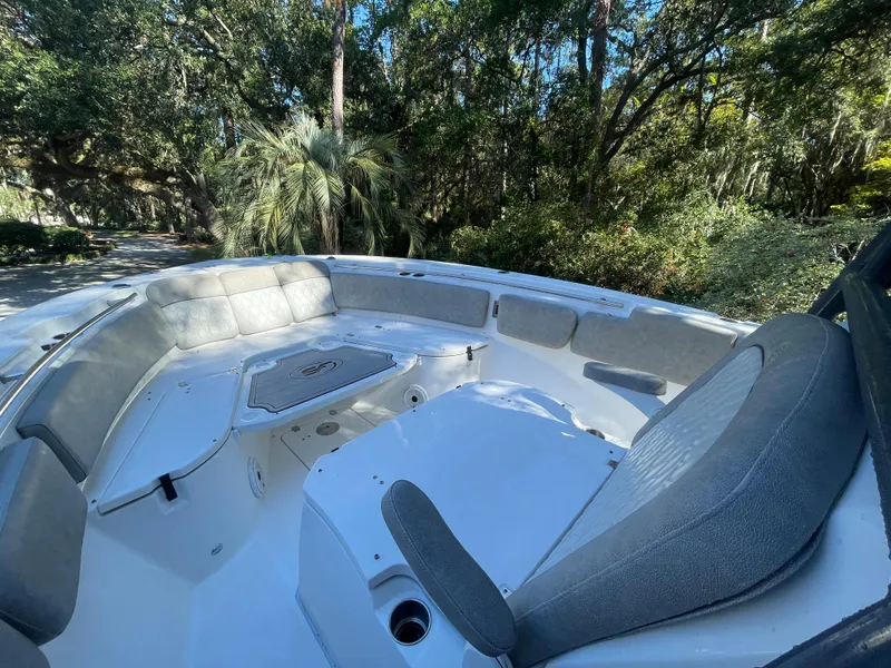 Slide: The Image of 2021 Sea Fox 288 Commander boat interior with cushioned seating in a wooded setting. - 8