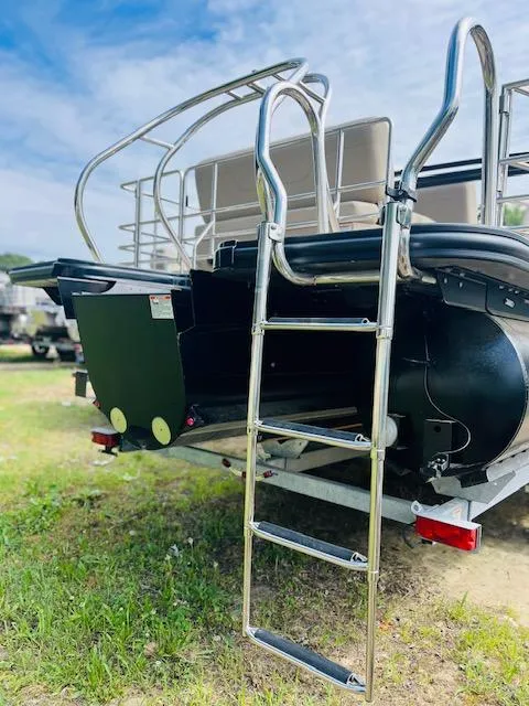 Slide: The Image of 2023 Starcraft CX 23 DL pontoon boat with ladder on grassy area. - 10