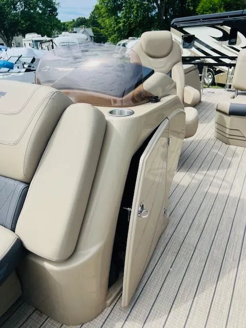 Slide: The Image of 2023 Starcraft CX 23 DL boat interior with beige seating and open storage compartment. - 7