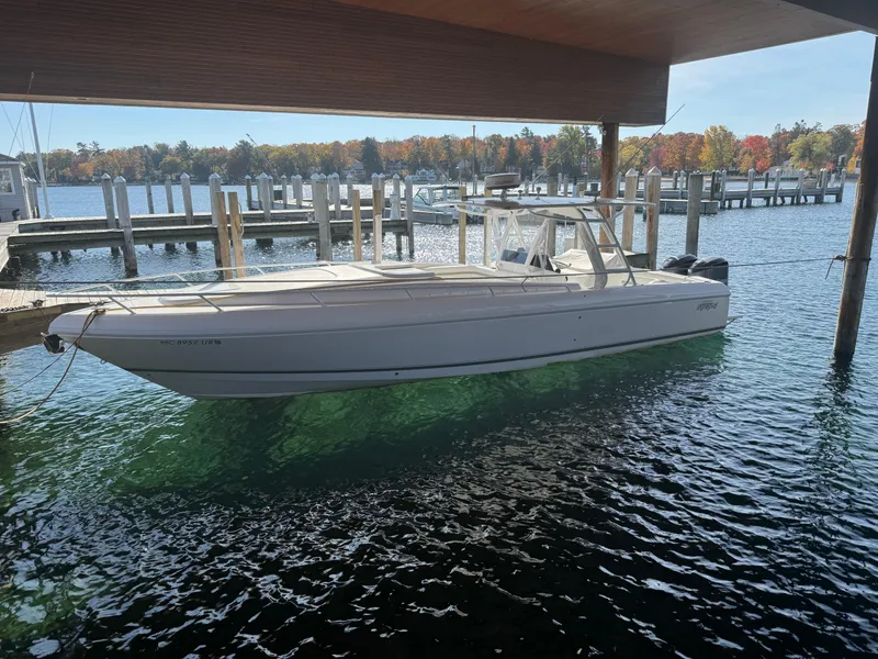 The Image of 2011 Intrepid 370 Cuddy boat docked in a scenic marina. - 0
