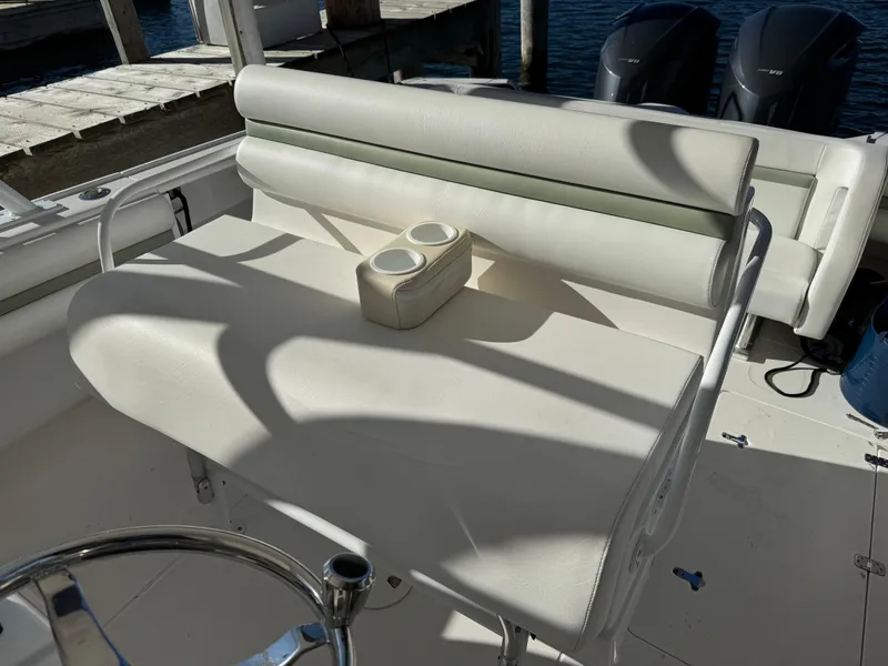 Slide: The Image of Intrepid 370 Cuddy 2011 boat seating with cup holders, docked by the water. - 19