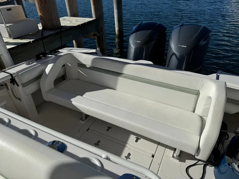 Slide: The Image of 2011 Intrepid 370 Cuddy boat interior with white seating and dual outboard engines. - 20