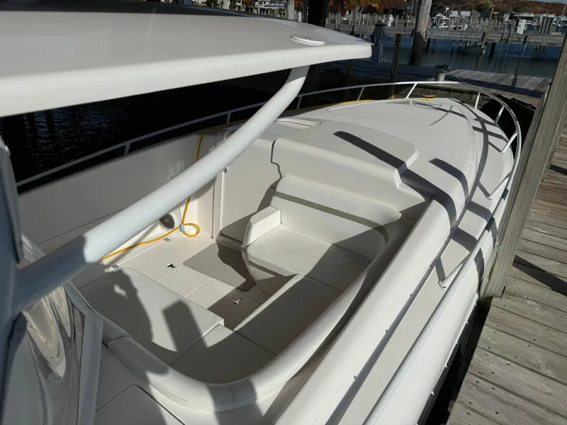 Slide: The Image of 2011 Intrepid 370 Cuddy boat docked, showcasing spacious deck and sleek design. - 6