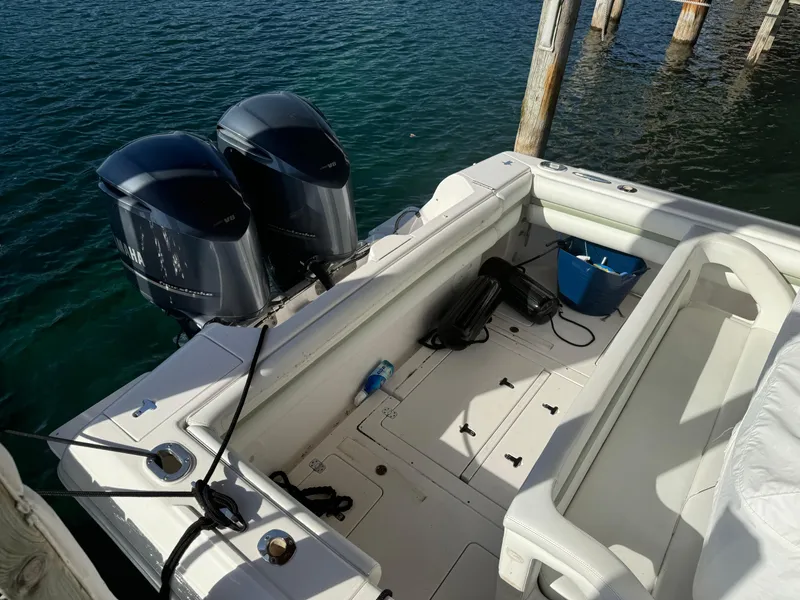 Slide: The Image of 2011 Intrepid 370 Cuddy boat with dual outboard engines docked by the water. - 7