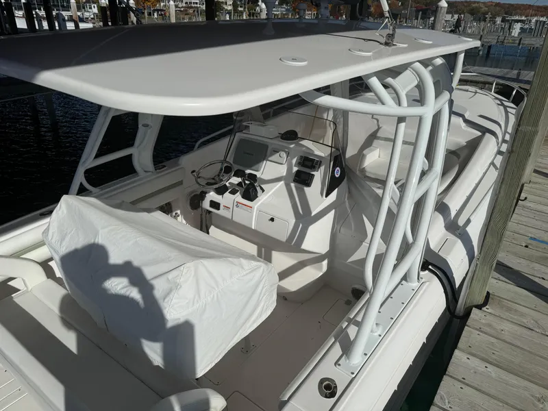 Slide: The Image of 2011 Intrepid 370 Cuddy boat with covered helm and seating area at dock. - 8