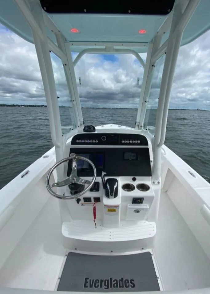 Slide: The Image of 2022 Everglades 243 Center Console boat on water, featuring modern helm and controls. - 10