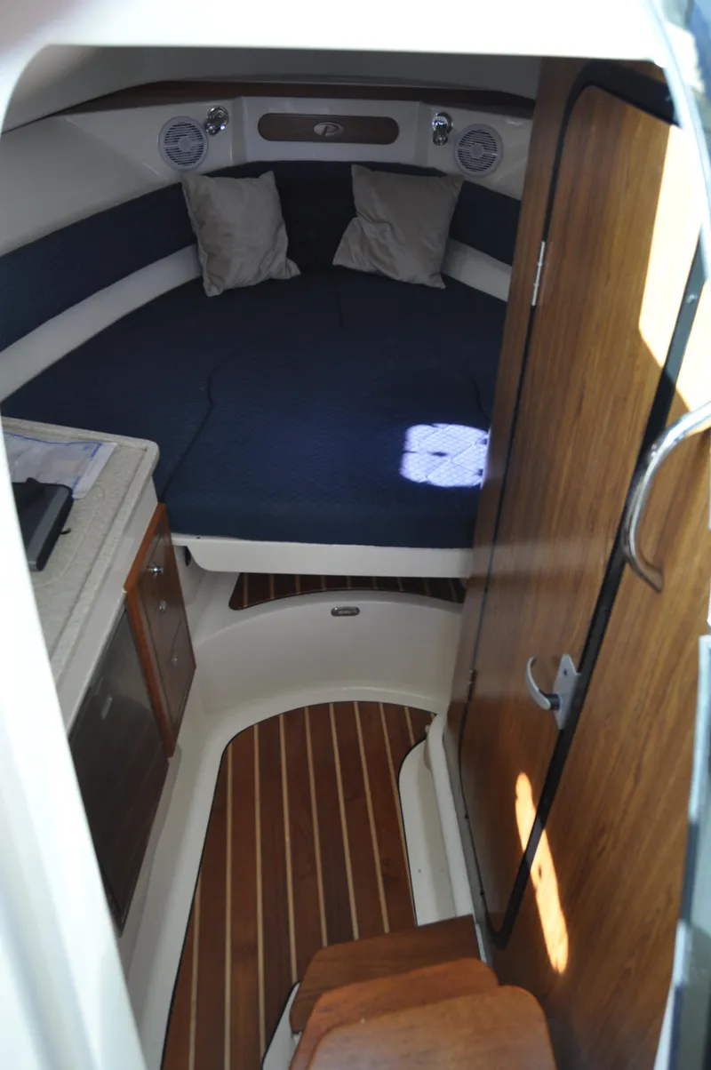 Slide: The Image of 2014 Pursuit OS 315 Offshore cabin interior with bed and wooden flooring. - 13