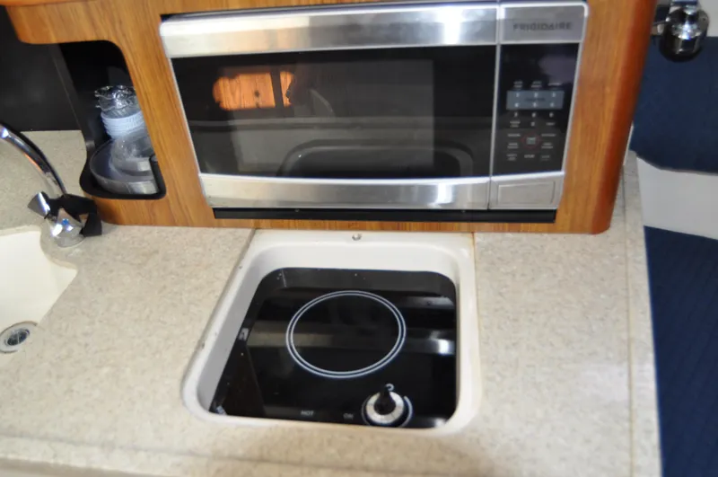 Slide: The Image of 2014 Pursuit OS 315 Offshore kitchen with microwave and stovetop. - 15