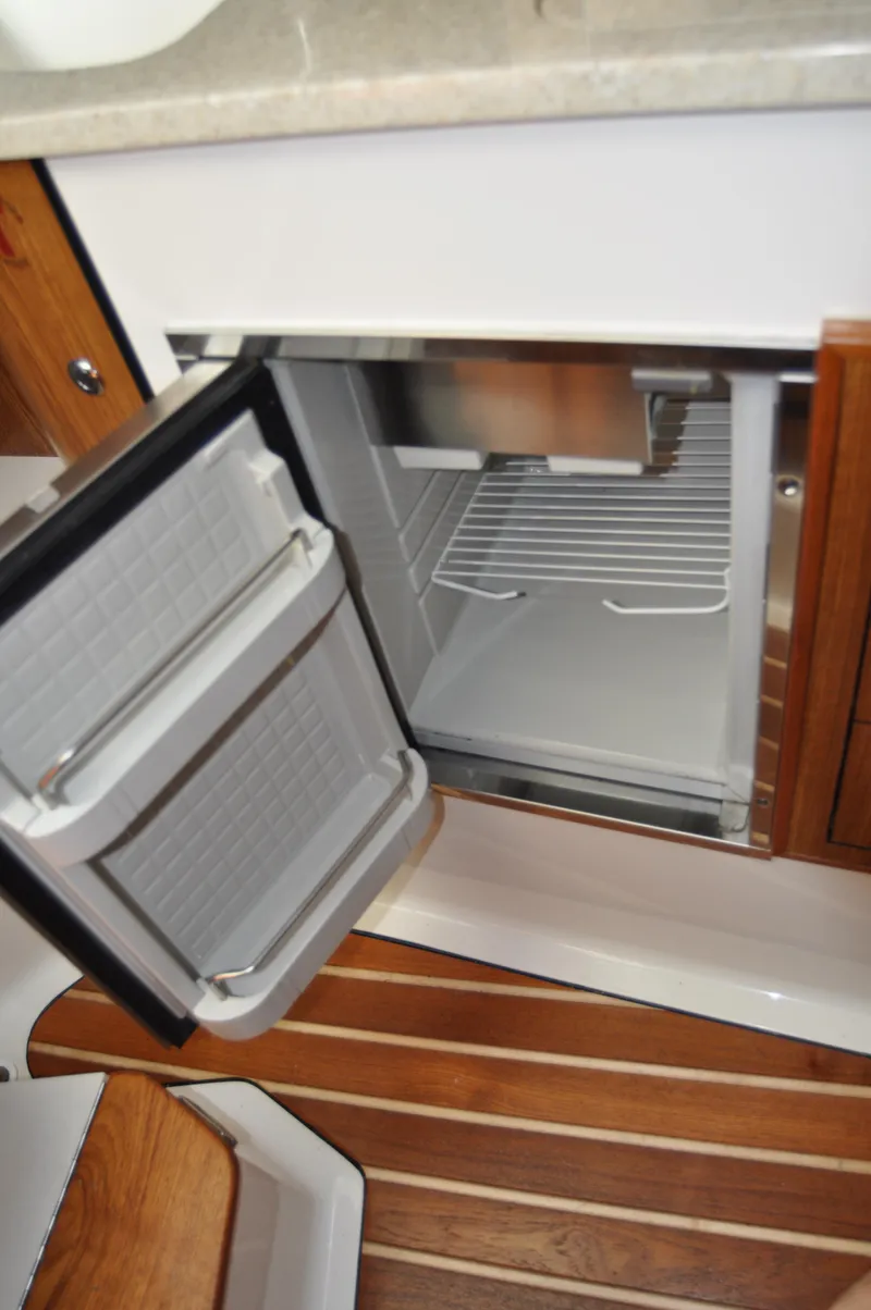 Slide: The Image of Open fridge in 2014 Pursuit OS 315 Offshore boat interior. - 18