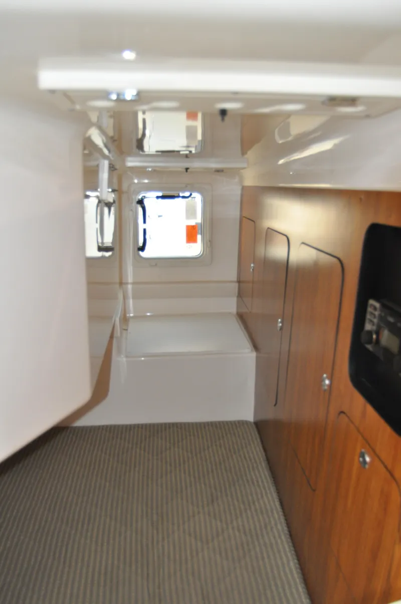 Slide: The Image of 2014 Pursuit OS 315 Offshore cabin interior with wood paneling and carpeted floor. - 19
