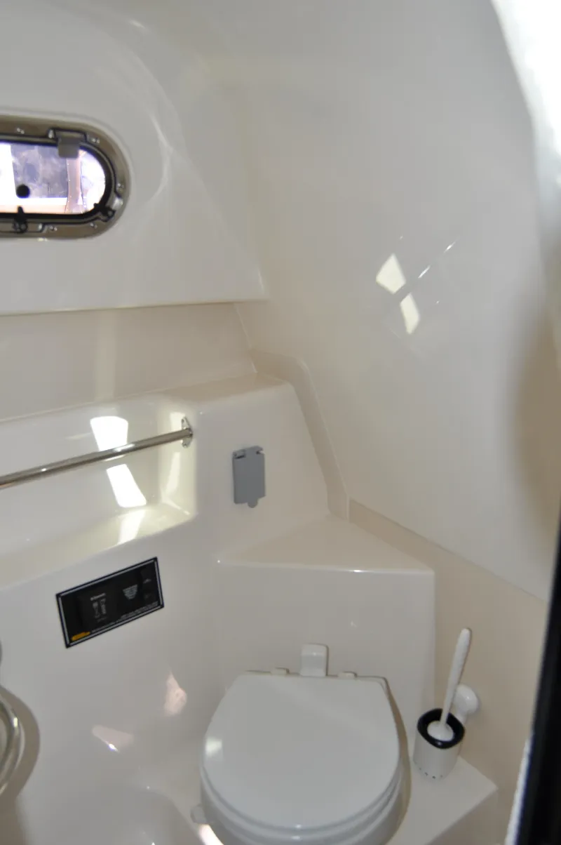 Slide: The Image of 2014 Pursuit OS 315 Offshore boat bathroom interior with porthole and toilet. - 21