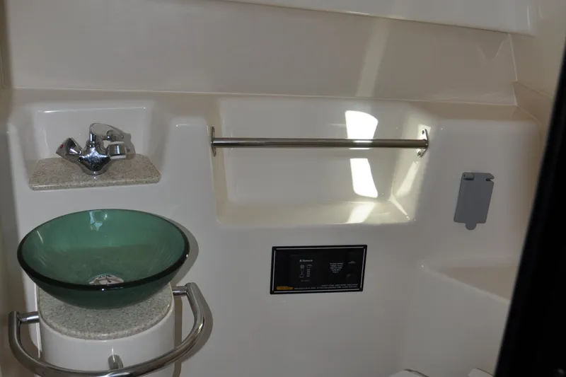 Slide: The Image of 2014 Pursuit OS 315 Offshore bathroom with glass sink and modern fixtures. - 22