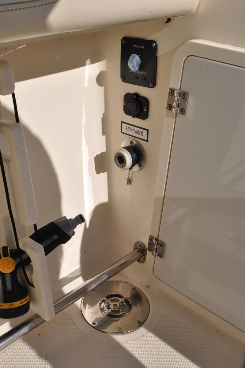 Slide: The Image of 2014 Pursuit OS 315 Offshore boat interior, featuring control panel and storage compartment. - 29