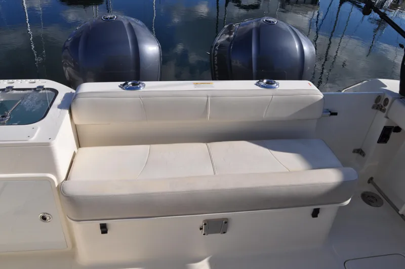 Slide: The Image of 2014 Pursuit OS 315 Offshore boat with cushioned seating and dual outboard motors. - 33